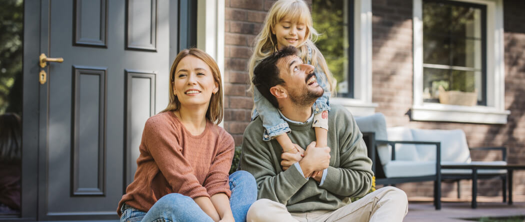 young family sitting outside on a front porch