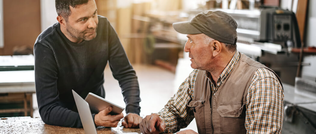 two men talking in a workshop