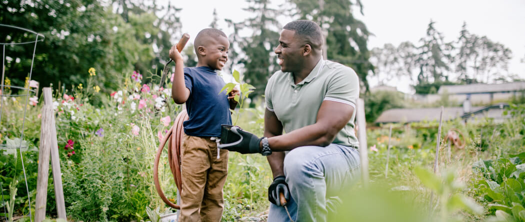 Dad and young son out in a garden 