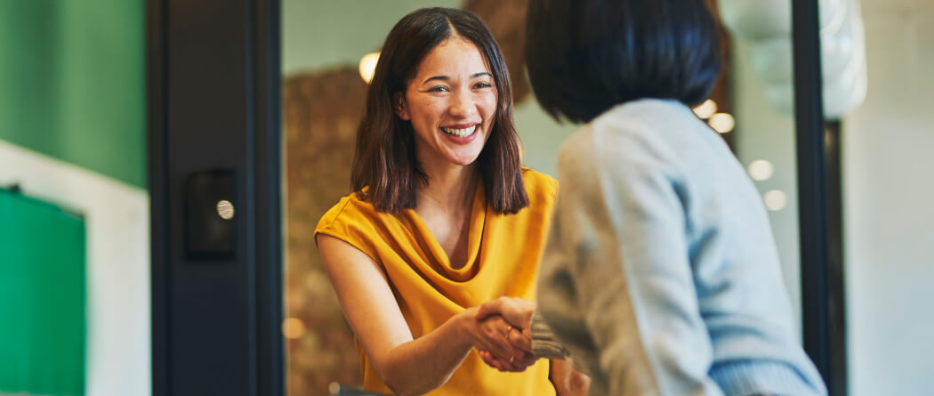 Two women shaking hands in an office