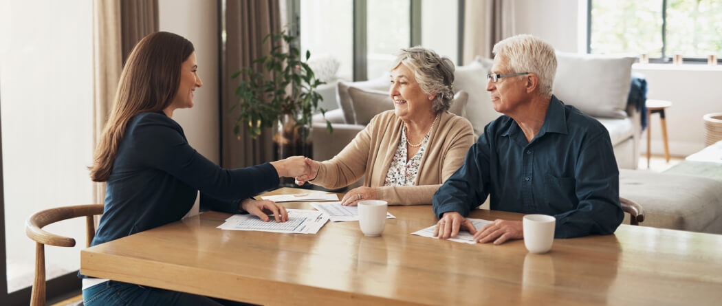 mature couple sitting at a table with a business woman