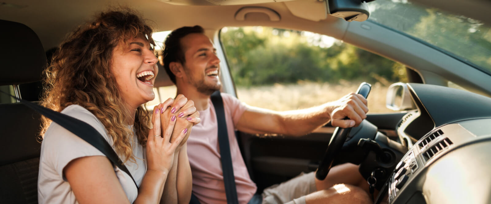 young couple holding hands in a car